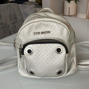 Steve Madden silver mini backpack w/ front zipper pocket.